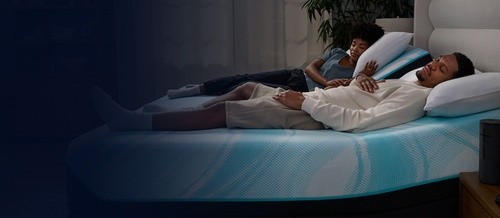 Couple sleeping on a LuxeBreeze Split Head King mattress fading into dark