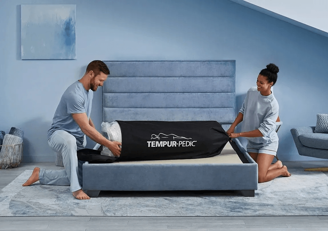 A joyous couple unbagging the Tempur-Cloud mattress-in-bag