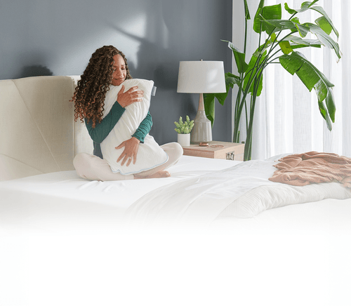 woman hugging tempurpedic pillow on mattress