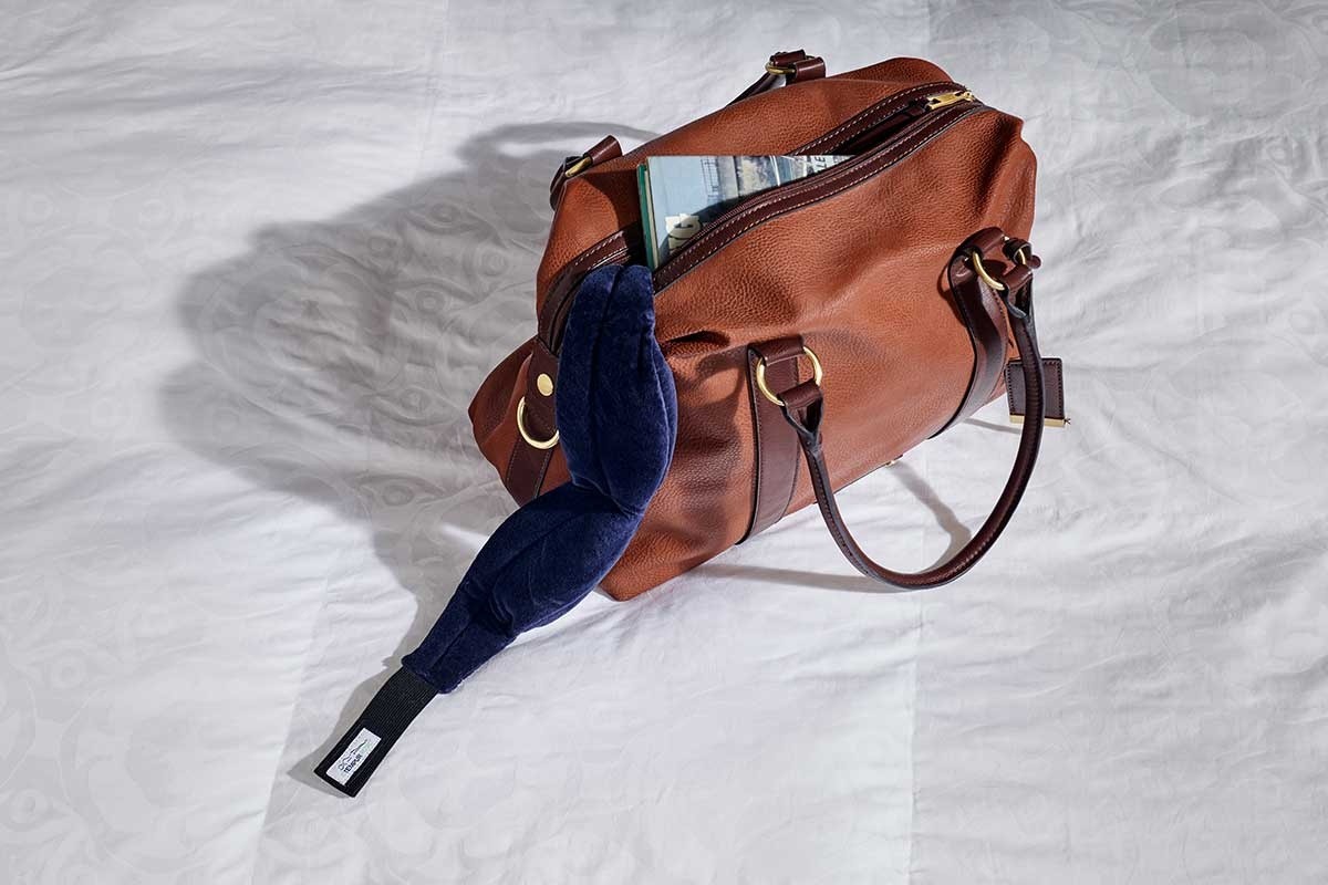 A travel bag with a sleep mask on top