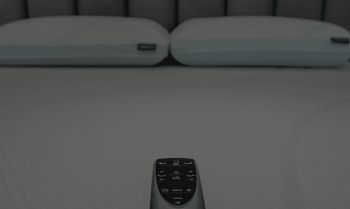 mattress with two pillows and a remote