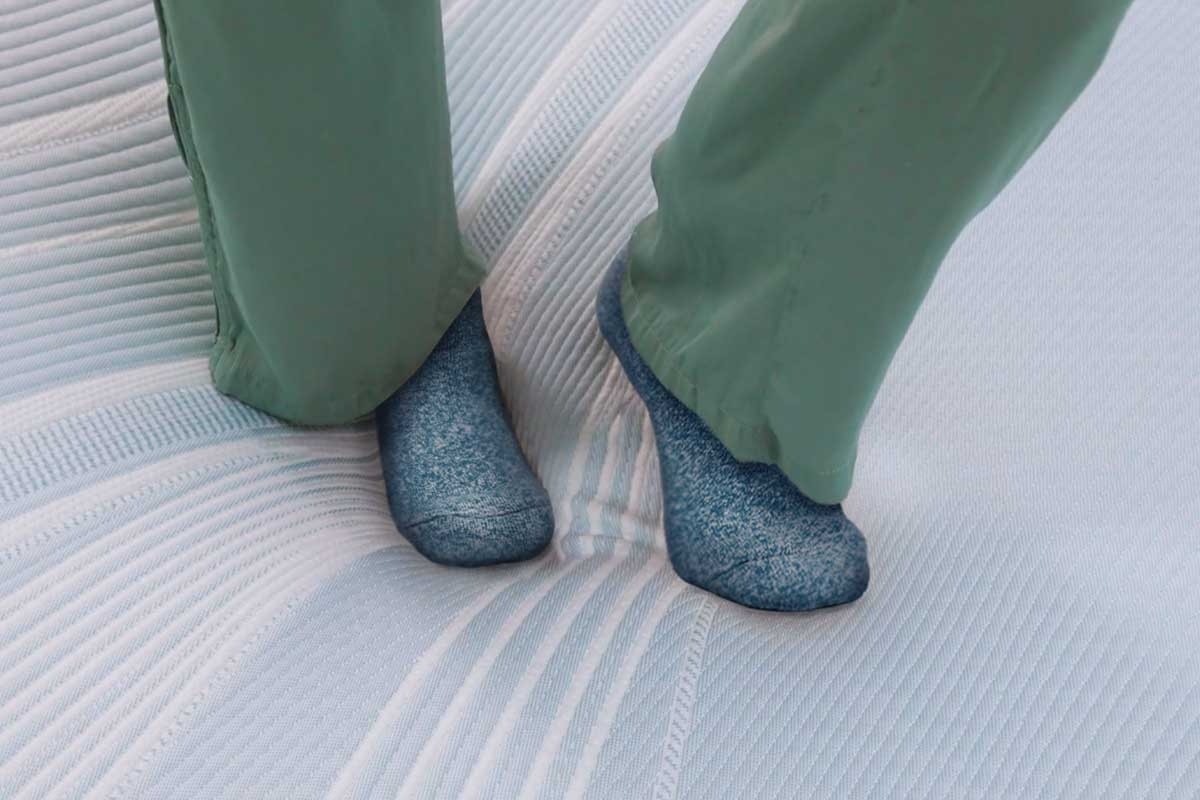 A close up of a TempurPedic mattress conforming as someone stands on it