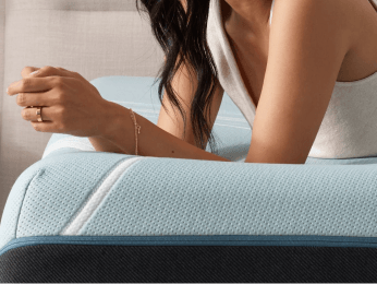 a woman arms leaning on the adapt mattress collection model