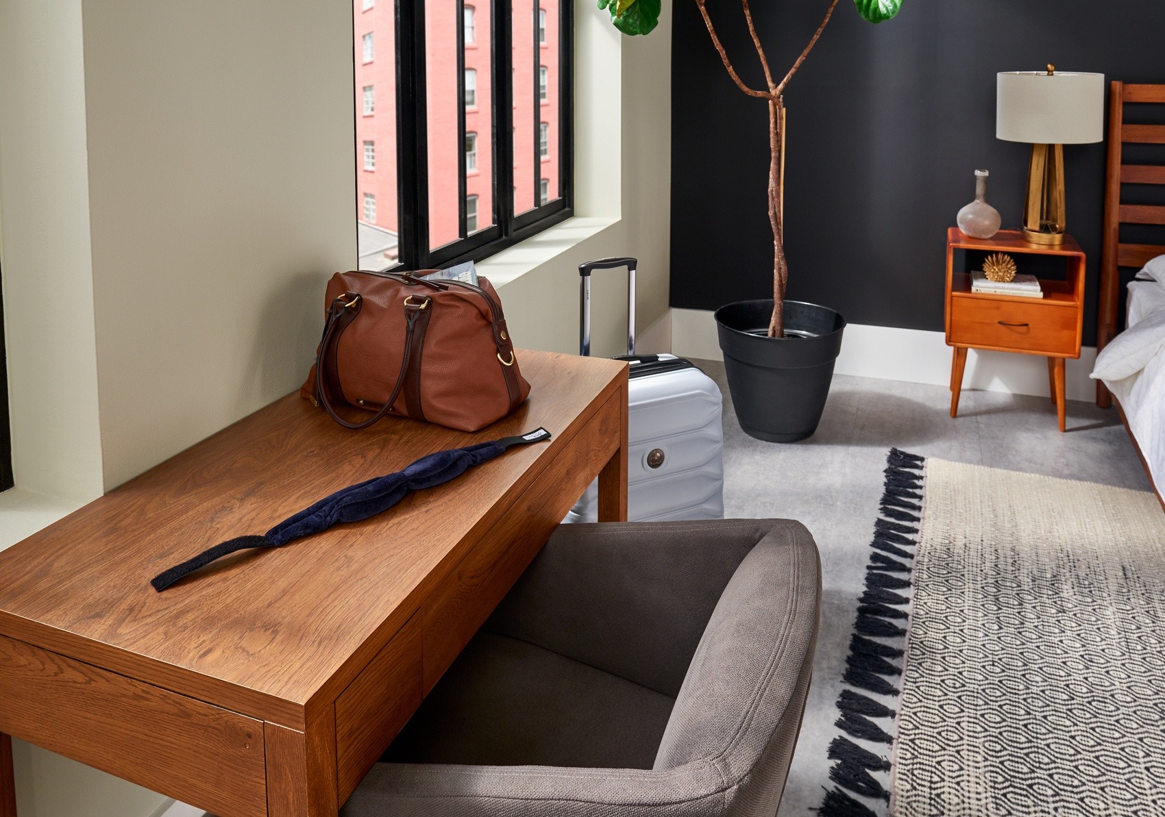 TEMPUR-Sleep Mask laying on a table near a bed